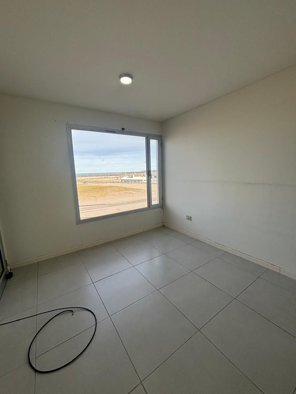 Dormitorio con una ventana grande que da a la costa y al mar