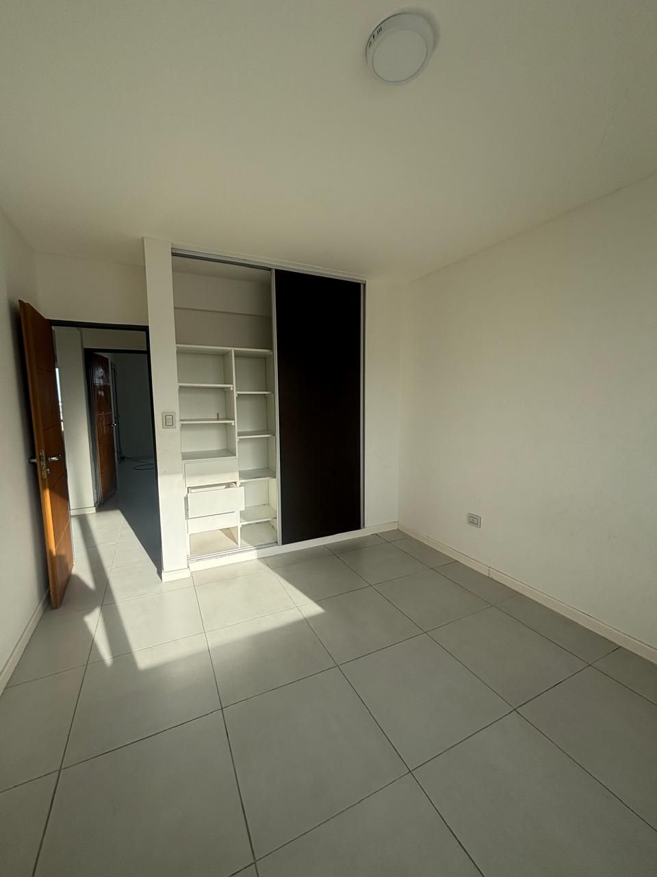 Dormitorio con placard empotrado de estantes y cajones